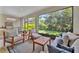 Relaxing screened-in patio with a comfortable seating area and views of the lush backyard and outdoor kitchen at 5320 Morey Farms Loop, Palmetto, FL 34221
