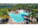 Overhead view of community pool and splashpad with lounge chairs, picnic tables, and tropical landscaping at 5320 Morey Farms Loop, Palmetto, FL 34221