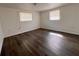 Simple bedroom with wood-look floors and windows providing natural light at 5507 Casino Dr, Holiday, FL 34690