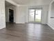 Bright open-concept living room with wood-look floors and access to the outdoor patio at 5507 Casino Dr, Holiday, FL 34690