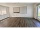 Bright room with wood-look floors and ample natural light from two large windows and a glass patio door at 5507 Casino Dr, Holiday, FL 34690