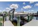 Boat on lift next to docks, showcasing waterfront property and boating access at 5722 Biscayne Ct # 107, New Port Richey, FL 34652