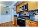 Kitchen featuring stainless steel appliances, granite countertops, tile backsplash, and wood cabinets at 5722 Biscayne Ct # 107, New Port Richey, FL 34652