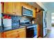 Kitchen featuring stainless steel appliances, granite countertops, tile backsplash, and wood cabinets at 5722 Biscayne Ct # 107, New Port Richey, FL 34652