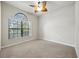 Neutral bedroom features a window with views of greenery, a ceiling fan and neutral carpeting at 5962 Lexington Dr, Parrish, FL 34219