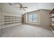 The bonus room features carpet flooring, built in shelving, natural light, and a ceiling fan at 5962 Lexington Dr, Parrish, FL 34219