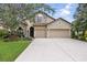 Charming two-story home with a three car garage, stone accents, and well-manicured lawn at 5962 Lexington Dr, Parrish, FL 34219