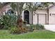 Close-up of the home's exterior and front yard showcasing landscaping, a three car garage and stone accents at 5962 Lexington Dr, Parrish, FL 34219