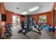 Bright fitness center with gym equipment and mirrored wall on orange accent wall at 6 Academy S Way # 221, St Petersburg, FL 33711