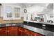 Modern kitchen features stainless steel sink, granite countertops, and natural wood cabinets at 6 Academy S Way # 221, St Petersburg, FL 33711
