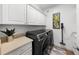 Bright laundry room features cabinetry, a countertop, and a modern washer and dryer at 6 Academy S Way # 221, St Petersburg, FL 33711