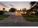 Charming single-story home with well-maintained lawn, fenced yard, and a spacious driveway illuminated by the sunset at 6119 31St N Ave, St Petersburg, FL 33710