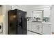 Kitchen with black refrigerator, white cabinets, and stainless steel sink providing modern conveniences at 6119 31St N Ave, St Petersburg, FL 33710