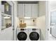 Well-lit laundry room with a new front-load washer and dryer set and storage cabinets at 6119 31St N Ave, St Petersburg, FL 33710
