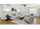 Inviting living room featuring hardwood floors, a comfortable white sofa, stylish chairs, and ample natural light, ideal for gatherings at 6119 31St N Ave, St Petersburg, FL 33710