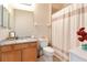 Bathroom featuring a granite vanity, wood cabinets, and a tub shower with curtain at 6513 Sand Shore Ln, New Port Richey, FL 34652