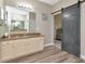 Elegant bathroom features a granite countertop, wood cabinets, and a modern barn door at 6513 Sand Shore Ln, New Port Richey, FL 34652
