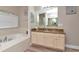 Luxurious bathroom with a soaking tub, granite countertops, and stylish vanity cabinets at 6513 Sand Shore Ln, New Port Richey, FL 34652