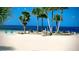 Beautiful beach scene with palm trees, inviting chairs and rocks, offering stunning waterfront views at 6513 Sand Shore Ln, New Port Richey, FL 34652
