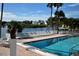 Outdoor pool area surrounded by waterfront views, palm trees, and comfortable lounge chairs at 6513 Sand Shore Ln, New Port Richey, FL 34652