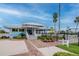 Inviting community clubhouse with a covered entrance, lush landscaping, and a blue sky at 6513 Sand Shore Ln, New Port Richey, FL 34652