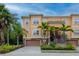 Charming townhome with a two-car garage and staircase, surrounded by lush green landscaping at 6513 Sand Shore Ln, New Port Richey, FL 34652