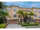Well-maintained townhome with a two-car garage and staircase, set amidst vibrant, tropical landscaping at 6513 Sand Shore Ln, New Port Richey, FL 34652