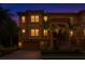 Inviting townhouse featuring warm exterior lighting, two-car garage and lush landscaping at twilight at 6513 Sand Shore Ln, New Port Richey, FL 34652