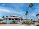 Beautiful community center with lush landscaping, white picket fence, and swaying palm trees at 6513 Sand Shore Ln, New Port Richey, FL 34652