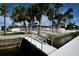 Charming waterfront home with white picket fence, dock access, and lush palm trees at 6513 Sand Shore Ln, New Port Richey, FL 34652