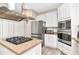 Well-equipped kitchen with stainless steel appliances, granite counters, island cooktop, and plenty of cabinet space at 6513 Sand Shore Ln, New Port Richey, FL 34652