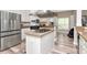 Modern kitchen with stainless steel appliances, granite countertops, and a central island with a cooktop at 6513 Sand Shore Ln, New Port Richey, FL 34652