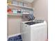 Bright laundry room with front load washer, dryer, and shelving for storage at 6513 Sand Shore Ln, New Port Richey, FL 34652