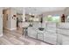 Open-concept living area with modern seating and views into the bright, spacious kitchen at 6513 Sand Shore Ln, New Port Richey, FL 34652