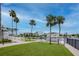 Manicured lawn leads to waterfront with boat docks and palm trees, providing picturesque scenery at 6513 Sand Shore Ln, New Port Richey, FL 34652