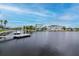Scenic waterfront view with multiple docks, featuring homes with boat access and clear skies at 6513 Sand Shore Ln, New Port Richey, FL 34652