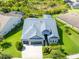 Overhead view of a home with a well-kept lawn and greenery, a large driveway, and a gray roof at 6817 Ebb Tide Ave, Apollo Beach, FL 33572