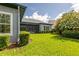A gorgeous view of the property's well-kept yard, mature landscaping, and enclosed patio at 6817 Ebb Tide Ave, Apollo Beach, FL 33572