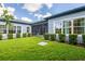 Beautiful backyard featuring a well-maintained lawn, landscaping, and a screened-in lanai at 6817 Ebb Tide Ave, Apollo Beach, FL 33572