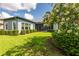 A peaceful backyard view featuring a manicured lawn, privacy landscaping, and a screened porch at 6817 Ebb Tide Ave, Apollo Beach, FL 33572