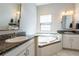 Bright bathroom features a large soaking tub, white cabinets, and granite countertops at 6817 Ebb Tide Ave, Apollo Beach, FL 33572