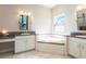 Elegant bathroom with double vanities, a soaking tub, and modern fixtures and finishes at 6817 Ebb Tide Ave, Apollo Beach, FL 33572