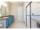 Bright bathroom features a shower, and vanity with granite countertops and blue cabinets at 6817 Ebb Tide Ave, Apollo Beach, FL 33572