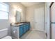 Bright bathroom featuring blue vanity, granite countertop and shower with decorative tile accents at 6817 Ebb Tide Ave, Apollo Beach, FL 33572