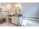 Bright bathroom features a large soaking tub, walk-in shower, and granite countertops at 6817 Ebb Tide Ave, Apollo Beach, FL 33572