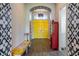 Striking foyer with yellow double doors, unique wall designs, and a colorful bench at 6817 Ebb Tide Ave, Apollo Beach, FL 33572
