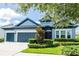 Attractive home with a manicured lawn, tree, symmetrical landscaping, and a two-car garage at 6817 Ebb Tide Ave, Apollo Beach, FL 33572