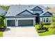 Beautiful home featuring a well-kept front lawn, tasteful landscaping, and a spacious driveway at 6817 Ebb Tide Ave, Apollo Beach, FL 33572