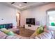 Comfortable living room with modern entertainment center, wood-look floors, and bright natural light at 6817 Ebb Tide Ave, Apollo Beach, FL 33572