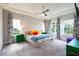 Serene main bedroom featuring a ceiling fan, tray ceiling, natural light, and modern decor at 6817 Ebb Tide Ave, Apollo Beach, FL 33572